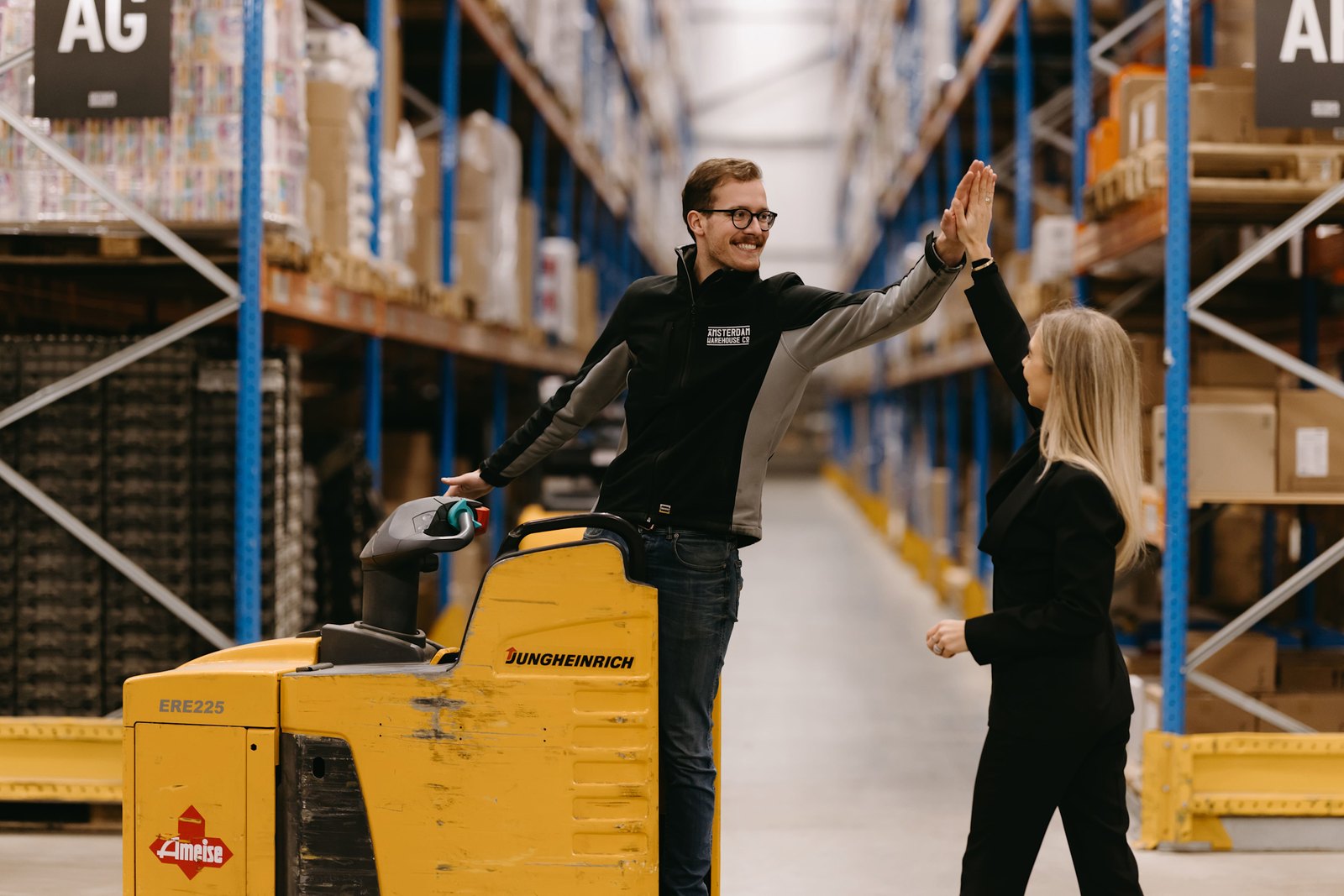Employees of AES International in the warehouse by an electric pallet truck